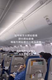 Passengers hold oxygen masks to their faces after their plane dropped 26,900ft.