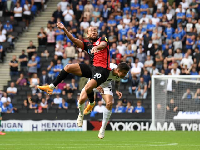 <p>Portsmouth’s Marcus Harness battles with Daniel Harvie during Dons’ 1-0 win over Portsmouth at Stadium MK</p>
