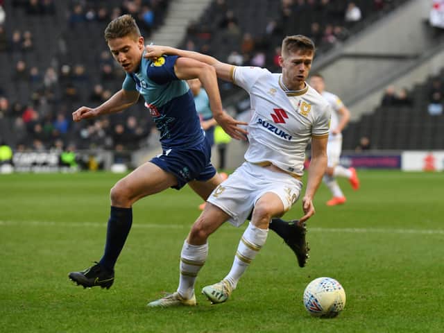 <p>Rhys Healey holds off former Dons loanee David Wheeler Wycombe Wanderers last came to Stadium MK in February 2020.</p>