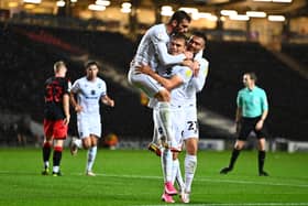 Troy Parrott and Daniel Harvie mob Scott Twine after scoring for MK Dons on Tuesday night. Twine’s hat-trick against Fleetwood Town helped Dons earn a point