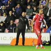 Liam Manning gives orders from the touchline against Wigan Athletic on Tuesday. The MK Dons head coach was pleased to see a new dimension to his side - holding on to a victory despite having less of the ball