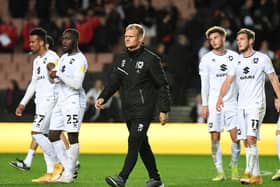 Liam Manning, flanked by some of the Dons youngsters to get a game against Aston Villa U21s, said it was a learning experience in the Papa John’s Trophy on Tuesday night as they went down 4-2