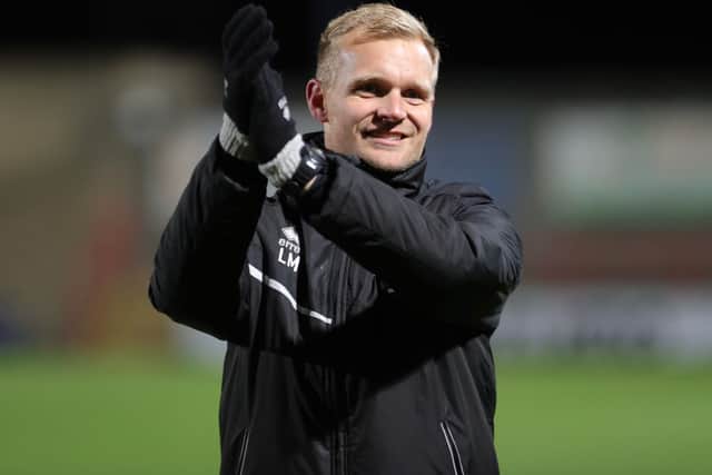 Liam Manning celebrates with the MK Dons supporters after the 4-0 win over Morecambe