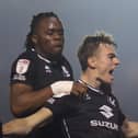 Peter Kioso joins Scott Twine in celebration after Dons came from 2-0 down against Lincoln City to win it 3-2 in the final minute