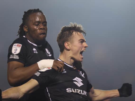 Peter Kioso joins Scott Twine in celebration after Dons came from 2-0 down against Lincoln City to win it 3-2 in the final minute
