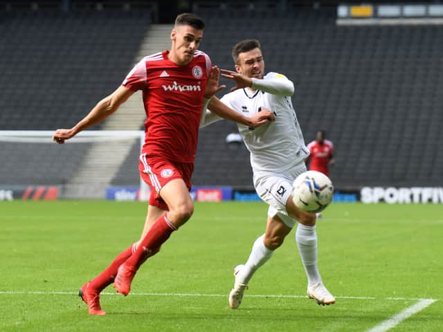 <p>Daniel Harvie battles for the ball in the reverse fixture between MK Dons and Accrington earlier this season</p>