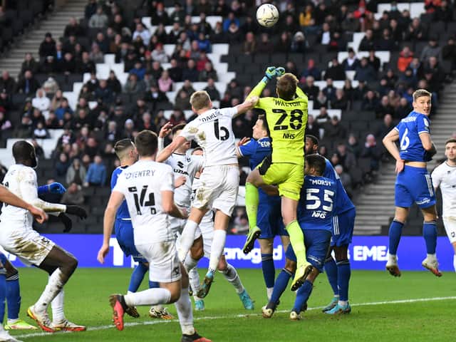 <p>Harry Darling goes up to challenge with Ipswich keeper Christian Walton</p>