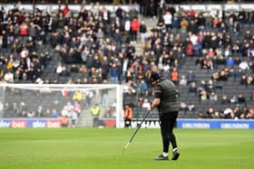 MK Dons ground staff tend to the pitch before the game with Ipswich on Saturday