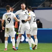 Connor Wickham celebrates with Scott Twine and Troy Parrott. Head coach Liam Manning believes the striker will be of great use to his young MK Dons squad as he passes on his experiences of playing at the top level