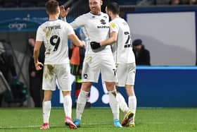 Connor Wickham celebrates with Scott Twine and Troy Parrott. Head coach Liam Manning believes the striker will be of great use to his young MK Dons squad as he passes on his experiences of playing at the top level