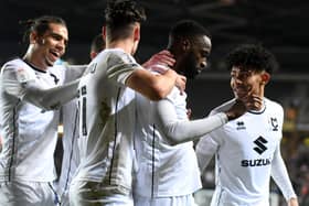 MK Dons celebrate Mo Eisa’s fourth goal in as many starts on Tuesday night against Cheltenham Town