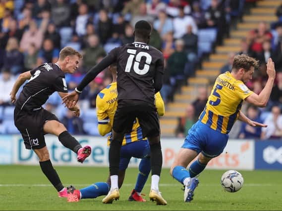 Scott Twine sees his shot blocked by Shrewsbury. Chris Hogg said Dons have gone back to the game at Montgomery Waters Meadow on several occasions to learn lessons this season.