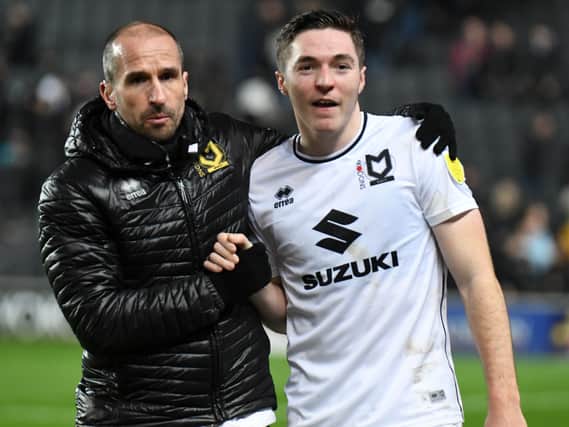 Conor Coventry gets a hug from MK Dons coach David Wright at Stadium MK. Coventry, on loan from West Ham, said the two halves of his season could not be more different after struggling for game time at Peterborough earlier this term.