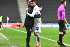 Liam Manning hugs goal-scorer Troy Parrott after the Irishman is substituted against Crewe Alexandra. The Dons head coach said he was having to  gee up his players after their 2-1 win at Stadium MK