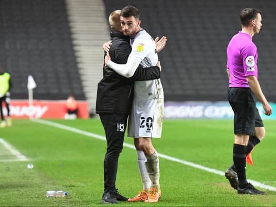 Liam Manning hugs goal-scorer Troy Parrott after the Irishman is substituted against Crewe Alexandra. The Dons head coach said he was having to  gee up his players after their 2-1 win at Stadium MK