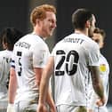 Dean Lewington and Troy Parrott celebrate the Irishman’s second goal against Cheltenham Town. The Dons skipper said he has a good working relationship with the on loan Spurs man