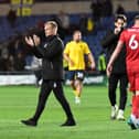 Liam Manning applauds the travelling 1,600 MK Dons supporters after the defeat to Oxford United