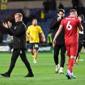 Liam Manning applauds the travelling 1,600 MK Dons supporters after the defeat to Oxford United