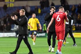 Liam Manning applauds the travelling 1,600 MK Dons supporters after the defeat to Oxford United