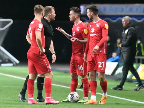 Josh McEachran leads the discussions with referee Anthony Backhouse during the 1-0 defeat to Oxford United. The former Chelsea midfielder said the first half at the Kassam Stadium was one of Dons’ best performances of the season.