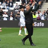 Liam Manning celebrates Dons’ win over Morecambe on Saturday. His side remain in with a chance of automatic promotion still heading into the final games next weekend.