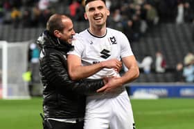 Warren O’Hora shares a laugh with coach David Wright. The defender said Dons are feeling no more pressure to win on Saturday against Plymouth than they normally do, despite an automatic promotion spot being the potential prize.