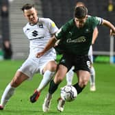 Josh McEachran battles for the ball when Dons met Plymouth back in December. Both sides need to win on the final day of the season when they play at Home Park