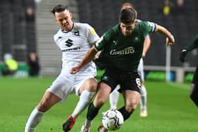 Josh McEachran battles for the ball when Dons met Plymouth back in December. Both sides need to win on the final day of the season when they play at Home Park