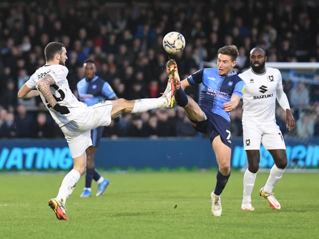 <p>Troy Parrott goes toe-to-toe with former Dons promotion hero David Wheeler when the sides met at Adams Park back in January. </p>