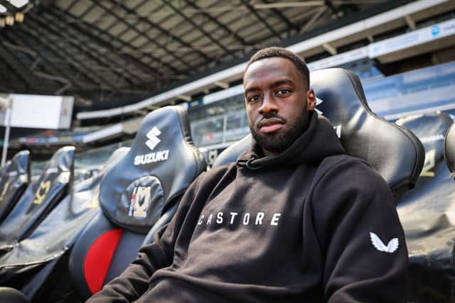 Dons striker Mo Eisa sporting a Castore hoodie. The brand will take over from Errea as the new kit manufacturer from next season