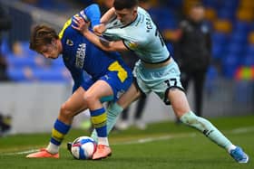 Conor Grant scraps for the ball against AFC Wimbledon’s Alex Woodyard. The 20-year-old ticks a lot of boxes for MK Dons, according to Liam Sweeting