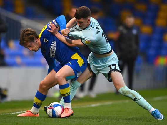 Conor Grant scraps for the ball against AFC Wimbledon’s Alex Woodyard. The 20-year-old ticks a lot of boxes for MK Dons, according to Liam Sweeting
