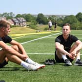 New signing Jack Tucker chats with Dons midfielder Dan Kemp. Dons have signed five players so far this summer.
