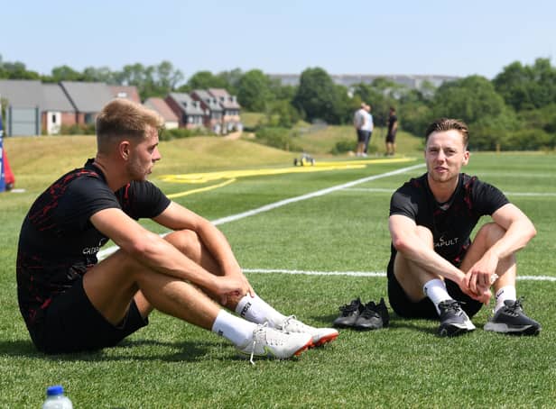 <p>New signing Jack Tucker chats with Dons midfielder Dan Kemp. Dons have signed five players so far this summer.</p>