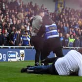 Stewards tackle someone invading the pitch during last season’s heated match between MK Dons and AFC Wimbledon at Plough Lane last season