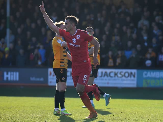 Warren O’Hora celebrates his strike at the Abbey Stadium last season, a goal which turned out to be the winner in March. Dons take on Cambridge United on the opening day of the season