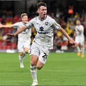 Darragh Burns capped a brilliant night for him by scoring Dons’ second of the night in their brilliant win over Watford. The Irishman also teed up Matt Dennis to score the first-half opener