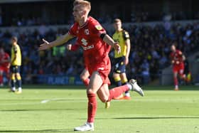 Matt Smith wheels off in celebration after scoring his first MK Dons goal... which may go down as a John Mousinho own goal yet