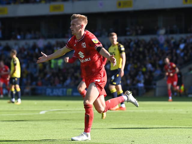 Matt Smith wheels off in celebration after scoring his first MK Dons goal... which may go down as a John Mousinho own goal yet