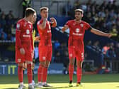 Warren O’Hora and Jack Tucker bark orders at Conor Grant during the 2-1 win over Oxford United on Saturday. Dons’ last eight goals conceded have come from dead ball situations