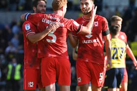 Will Grigg, Dean Lewington and Warren O’Hora celebrate MK Dons’ win over Oxford United last time out