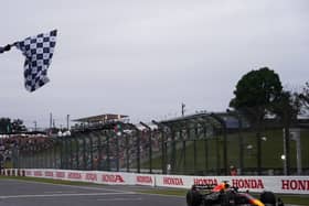 Max Verstappen crosses the line to win the Japanese Grand Prix and claim his second world championship