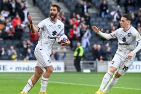 Will Grigg tries to lift the crowd after scoring Dons’ goal on Saturday in the 4-1 defeat to Plymouth Argyle