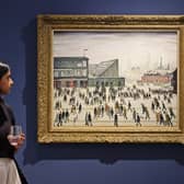 A visitor walks past "Going to the Match" by English artist LS Lowry from 1928, on display at a Christie's exhibition in Dubai on September 15, 2022