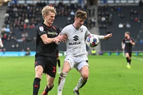 Ethan Robson battles with another former Dons loanee Lasse Sorensen on Saturday against Lincoln City