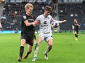 Ethan Robson battles with another former Dons loanee Lasse Sorensen on Saturday against Lincoln City