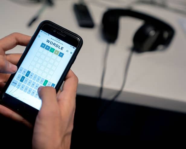 This photo illustration shows a person playing online word game “Wordle” on a mobile phone in Washington, DC on January 11, 2022 (Photo by STEFANI REYNOLDS/AFP via Getty Images)