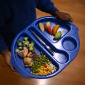 A child carries a tray with food during lunch-break at St Mary’s RC Primary School, in Battersea, south London.