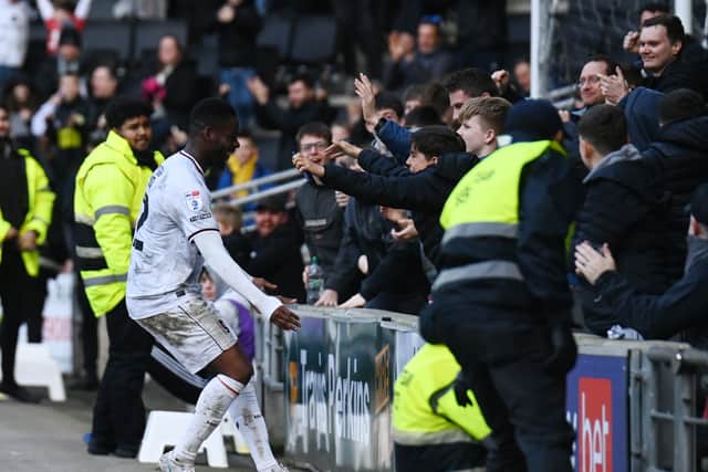 Jonathan Leko goes to celebrate with the fans in the Cowshed after scoring the only goal against Morecambe