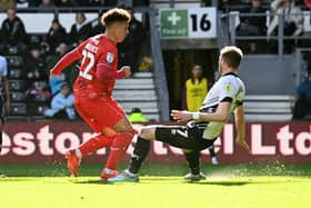 Henry Lawrence’s second-half strike earned Dons a point at Derby County on Easter Monday